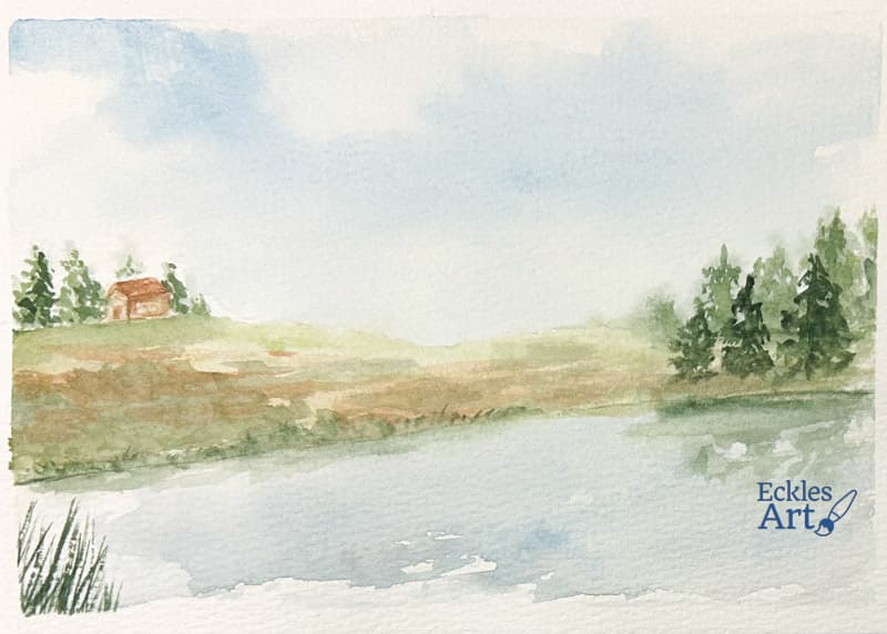 A peaceful lakeside landscape. The scene features a calm body of water in the foreground, reflecting soft blue and green hues. The middle ground has a gently sloping grassy hill with earthy tones, leading up to a small rustic cabin nestled among a cluster of evergreen trees on the left. More trees line the right side, adding depth and framing the scene. The background consists of a pale blue sky with wispy clouds, creating a tranquil and airy atmosphere.